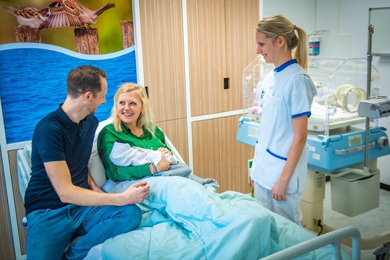 foto van ouders met baby in de gezinssuite met verpleegkundige