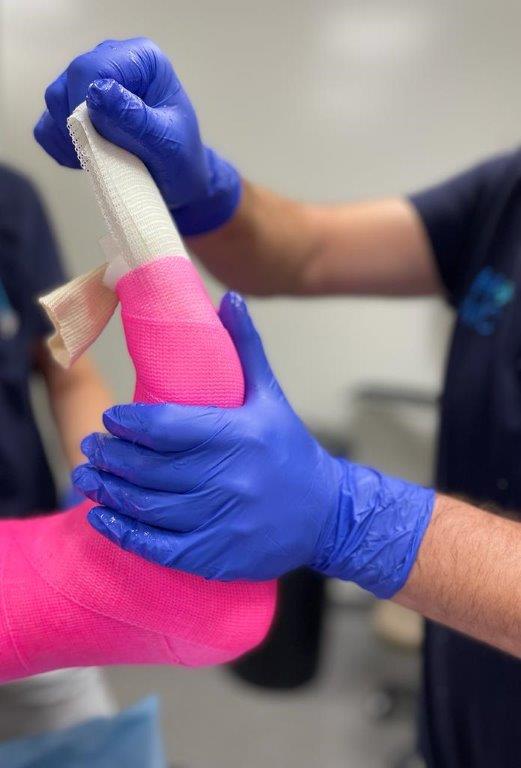 Gipsmeester Marc van der Laan uit HMC legt roze gips aan bij een patiënt