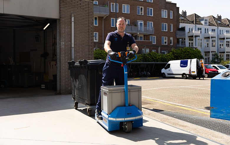 Joost op een elektrokar haalt 2 keer per dag op alle afdelingen afval op.