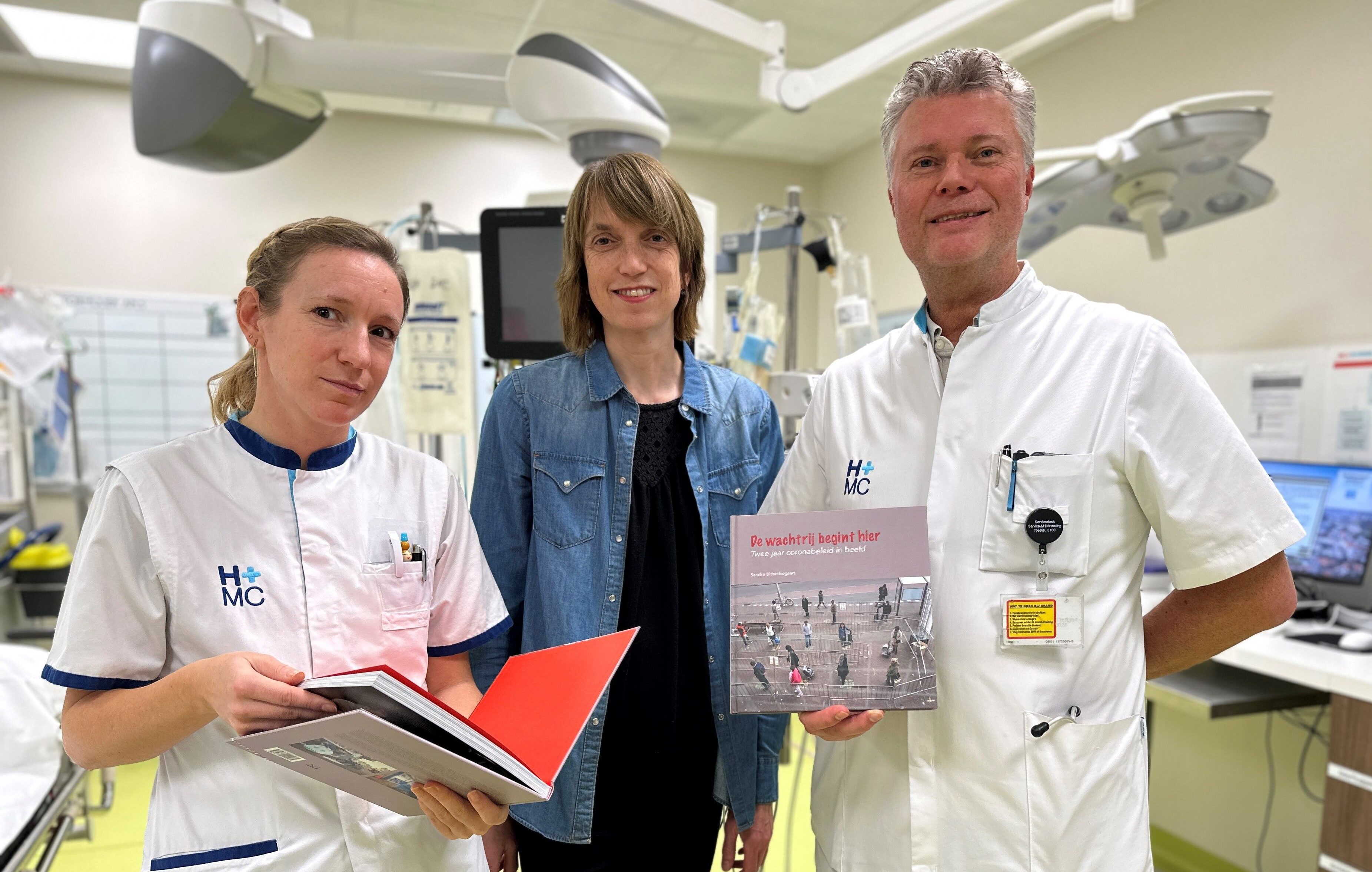 Infectioloog Luc Gelinck en IC-verpleegkundige Leandra Dubbink nemen een fotoboek over coronatijd in ontvangst.