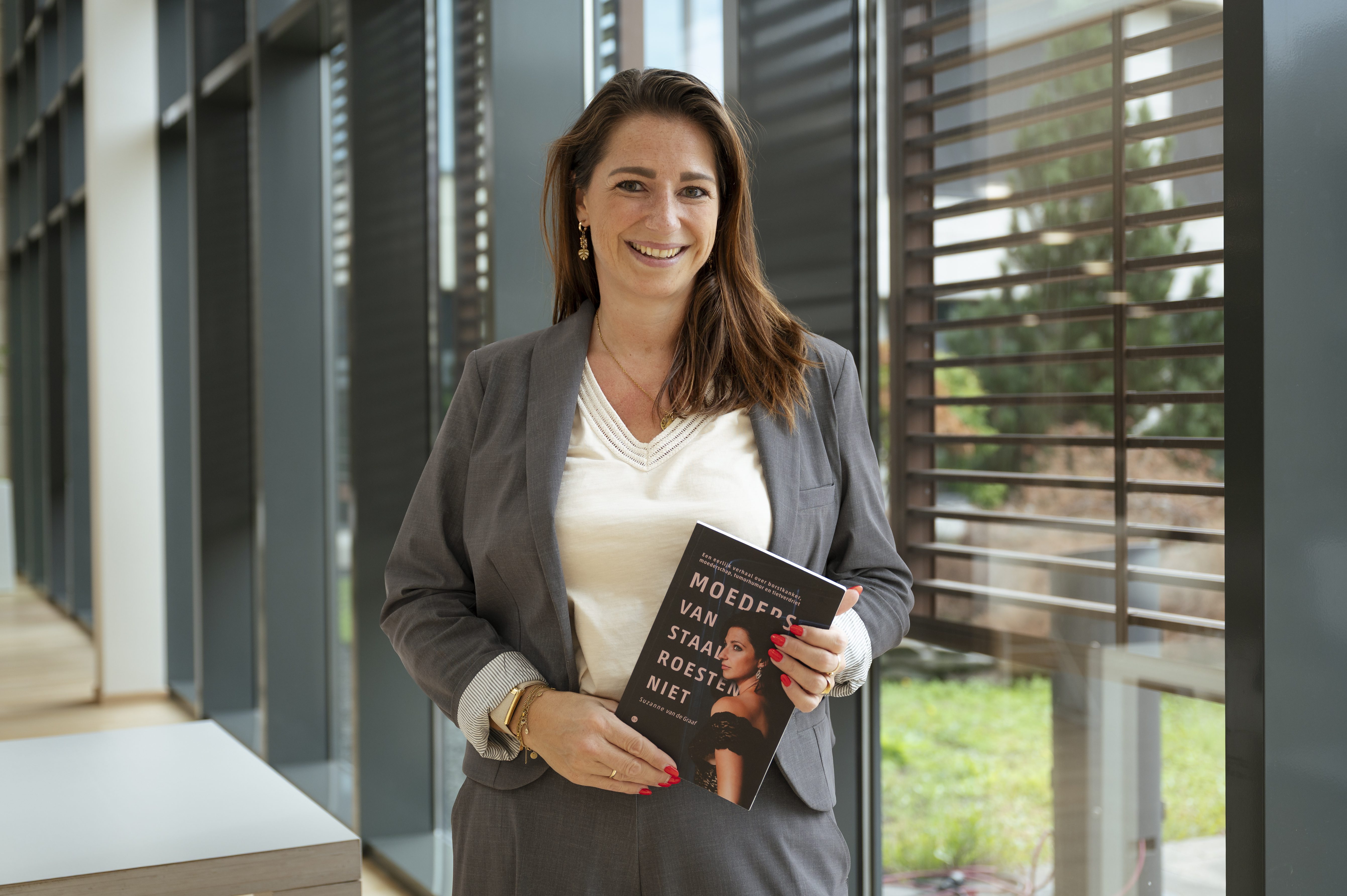 Portretfoto van Suzanne met boek over kanker